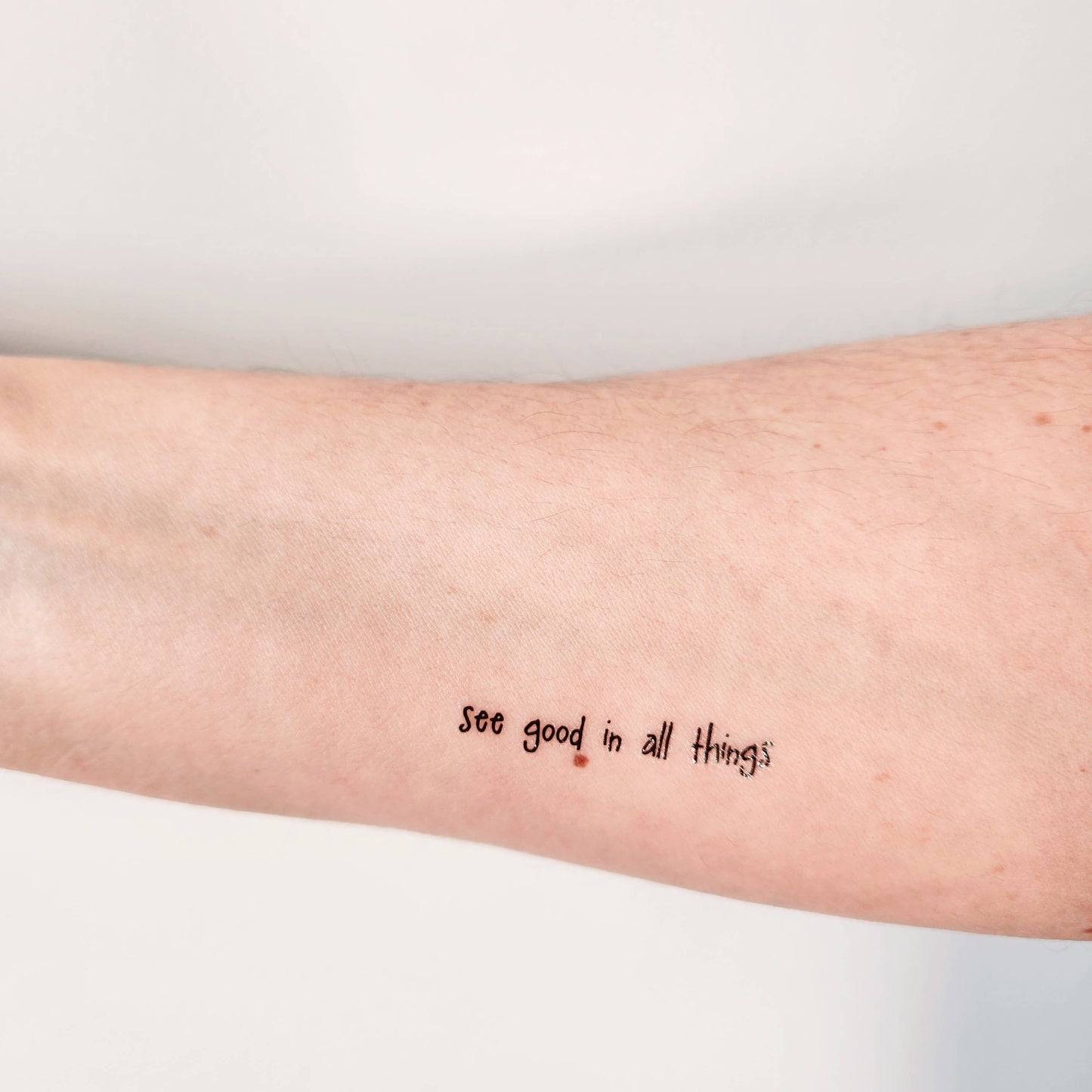 Temporary tattoo of the phrase "see good in all things"