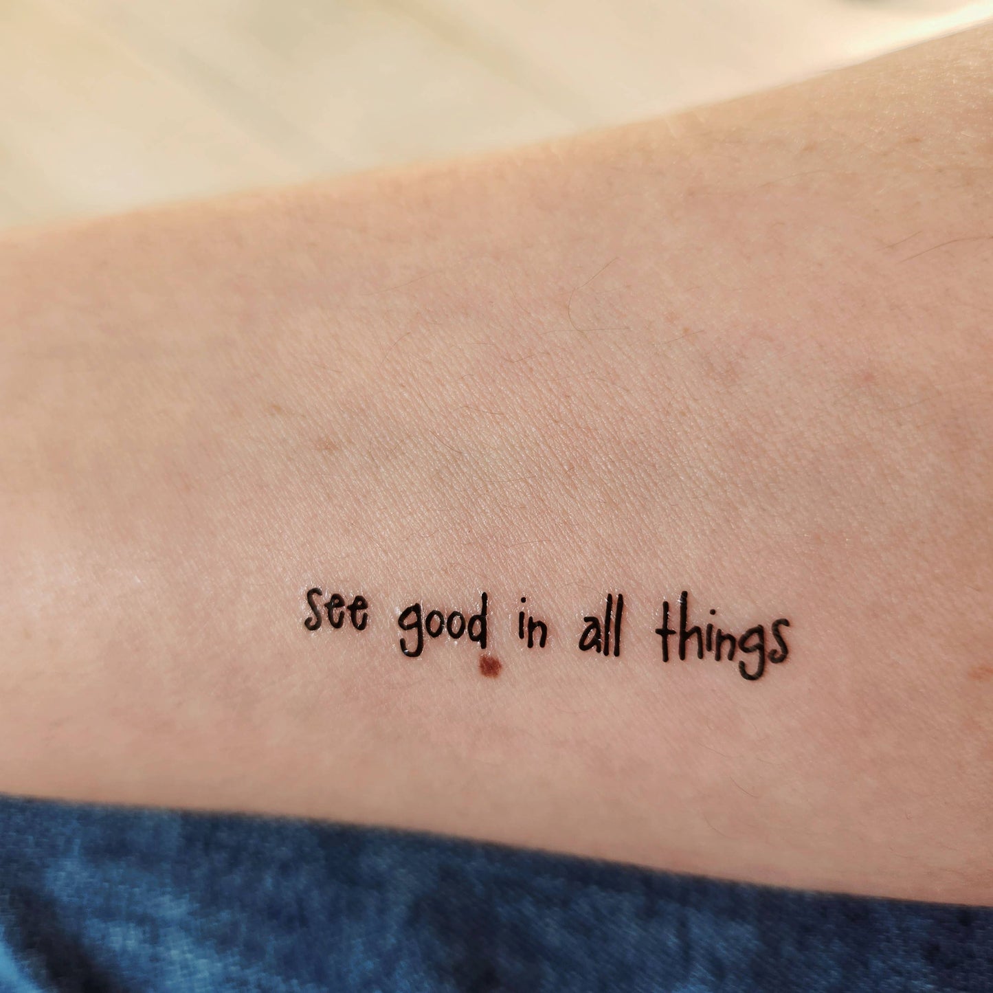Temporary tattoo of the phrase "see good in all things"